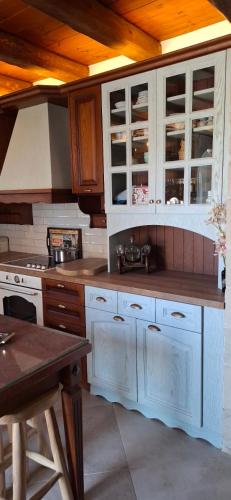 a kitchen with white cabinets and a wooden ceiling at Villa Quercus in Alikampos