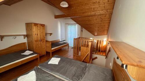 a room with two beds and a wooden ceiling at Apartman 343 - Aquapark Tatralandia, Holiday village in Liptovský Mikuláš