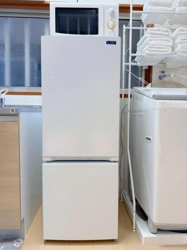 a white refrigerator with a microwave on top of it at 花の宿 in Osaka