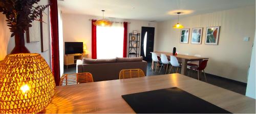 un salon avec un canapé, une table et des chaises dans l'établissement Entre océan, lacs et forêts, à Parentis-en-Born