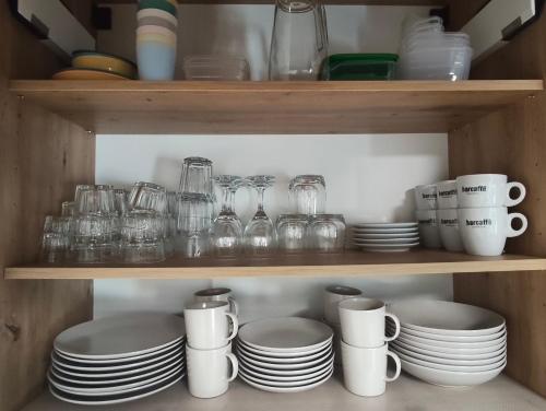 a shelf filled with plates and cups and dishes at Hiška 4005 - Terme Čatež in Brežice