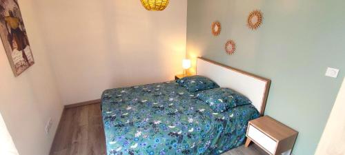 une chambre avec un lit avec une couette bleue dans l'établissement Entre océan, lacs et forêts, à Parentis-en-Born