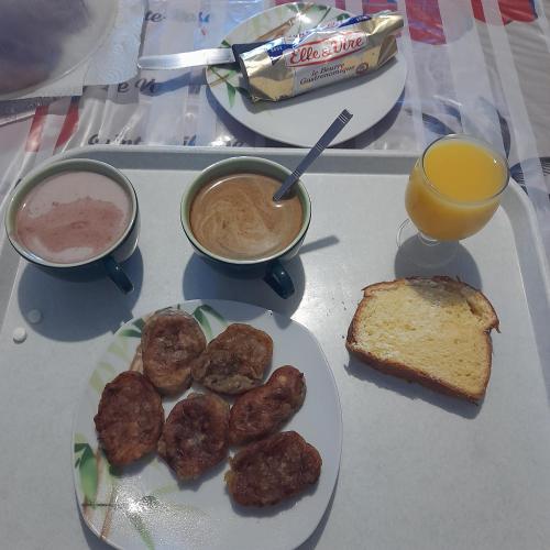 un plateau de nourriture avec des beignets, du café et du pain grillé dans l'établissement Chambres de charme en Normandie, à Hauterive
