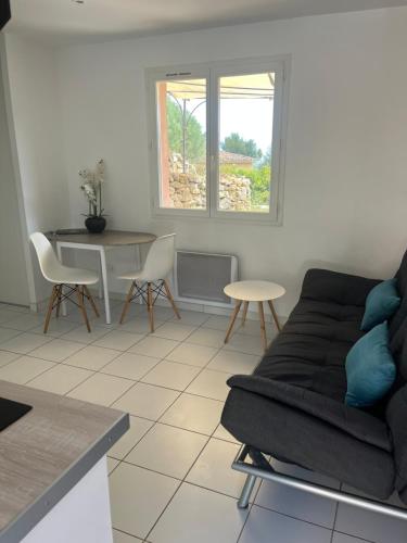un salon avec un canapé et une table dans l'établissement Hauteurs de Toulon : Charmant studio piscine, à Toulon