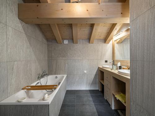 ein Badezimmer mit Badewanne und Waschbecken in der Unterkunft Chalet spacieux près des pistes avec sauna et WiFi, animaux admis - FR-1-567-69 in Val dʼIsère