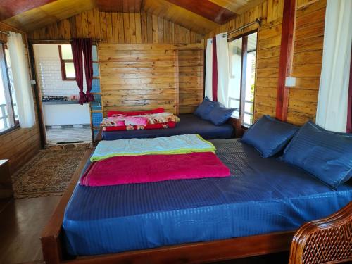 a bedroom with two beds in a wooden cabin at MISBHA HomeStay in Kodaikānāl