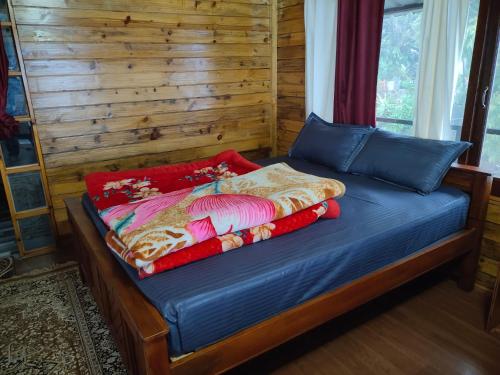 a bed in a room with a wooden wall at MISBHA HomeStay in Kodaikānāl