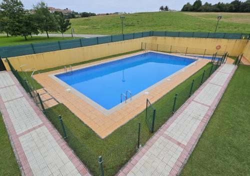 an overhead view of a swimming pool in a field at Casa Arenal COMILLAS, grande, céntrico y tranquilo, con jardín y piscina, ideal para familias in Comillas