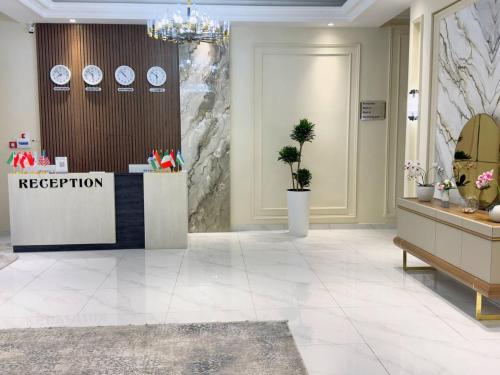 a lobby with a reception desk and clocks on the wall at Turon City Hotel in Samarkand