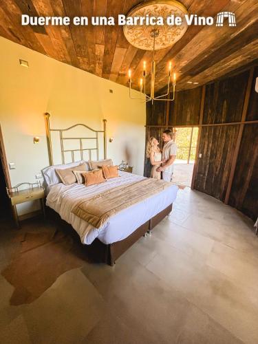 a man and woman standing next to a bed in a room at Cava Colchagua Hotel Boutique in Santa Cruz