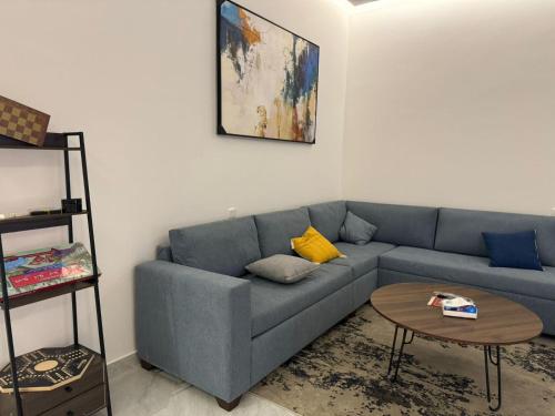 a living room with a blue couch and a table at شقق الدانة وصول ذاتي in Hafr Al Baten