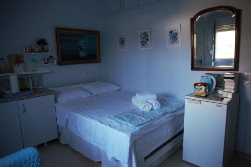a small bedroom with a bed and a mirror at Bluefullstop-Μπλε Τελεία in Artemida