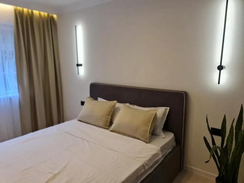 オシにあるПосуточноの白いシーツと枕が備わったベッドのある寝室