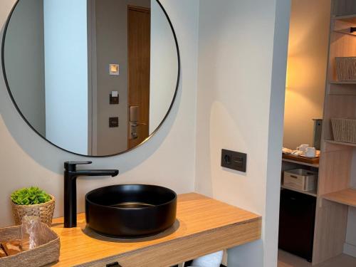 a bathroom with a black sink and a mirror at Hotel Farsund in Sanxenxo