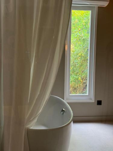 a bathroom with a tub in front of a window at Hotel Farsund in Sanxenxo