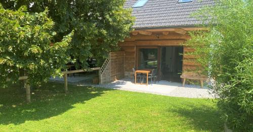 a cabin with a table and a chair in front of it at Log Garden Estate in Dobrova