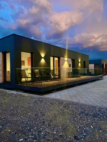 a black building with tables and chairs on it at Chalet du calme Gersthofen in Gersthofen