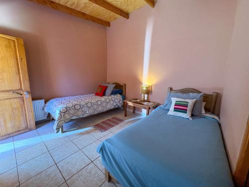 a room with two beds and a couch in it at Hostal Hara in San Pedro de Atacama