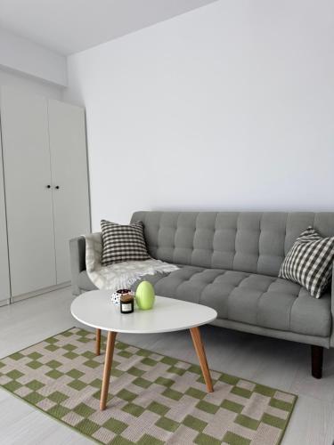 a living room with a couch and a table at Studio K Central - New building & private parking in Bucharest