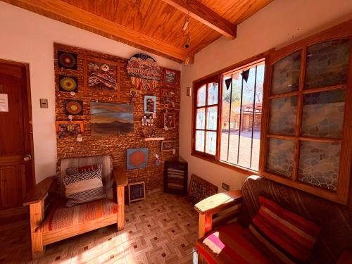 a living room with a couch and a brick wall at Hostal Hara in San Pedro de Atacama