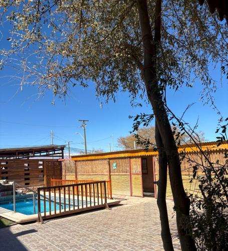 a wooden bench sitting next to a swimming pool at Hostal Hara in San Pedro de Atacama