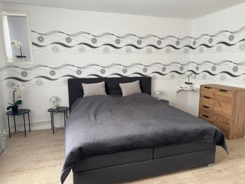 a bedroom with a large bed with a large headboard at Ferienwohnung in Glücksburg