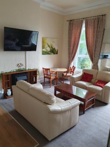 a living room with white couches and a table at Manhattan Lodge in Lytham St Annes