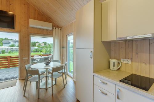 a kitchen and dining room with a table and chairs at Namelis Genio 7 in Palanga