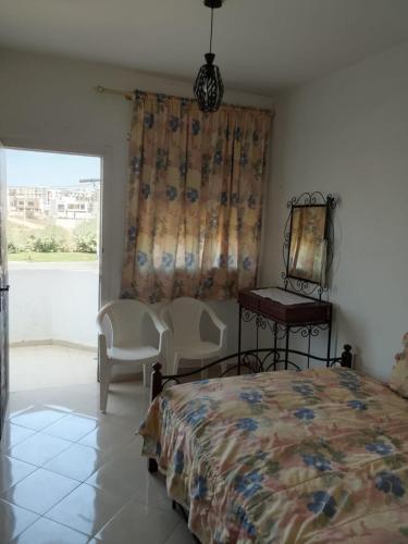 a bedroom with a bed and a table and a mirror at Appartement de vacance à Tanmia Bloc 13 in Martil