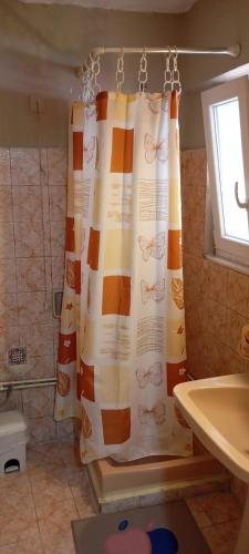 a bathroom with a shower curtain and a sink at Giannis Valeria in Rhodes Town