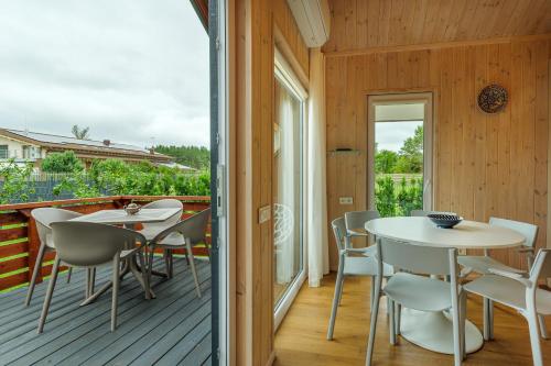a room with a table and chairs on a deck at Namelis Genio 7 in Palanga