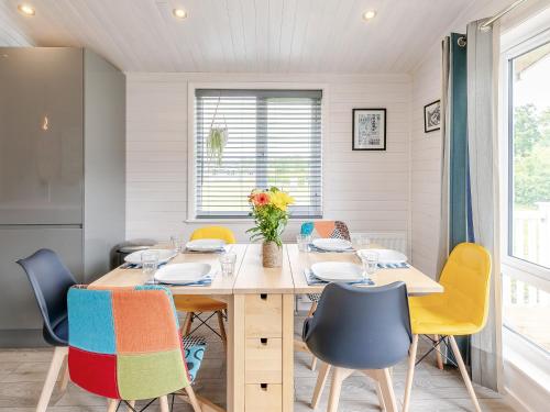 a dining room with a table and chairs at Erica Lodge in Willington
