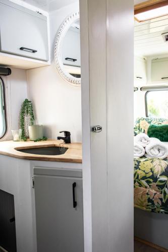 a kitchen in an rv with a counter and a sink at Tranquility Glamping in Winterton
