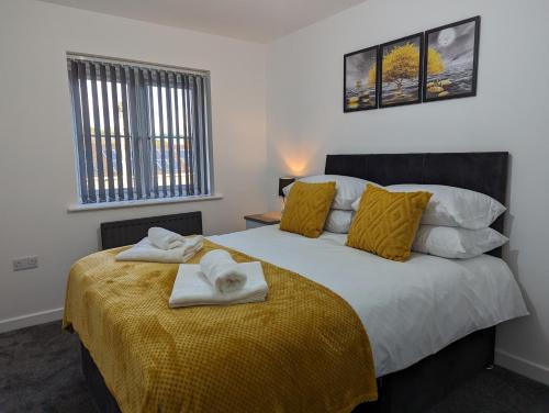 a bedroom with a large bed with towels on it at Leyland Road Retreat - 4 Bedroom House in Burnley