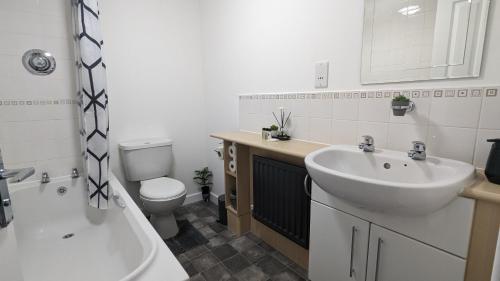 a bathroom with a sink and a tub and a toilet at Leyland Road Retreat - 4 Bedroom House in Burnley