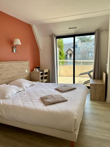 a bedroom with a bed and a large window at Hotel Castel Moor in Le Croisic