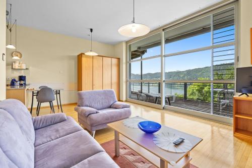 a living room with a couch and a table at Auszeit Seeblick Panorama in Millstatt
