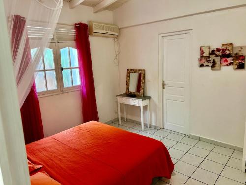 デエエにあるStudio La Margueriteのベッドルーム(赤いベッド1台、鏡付)