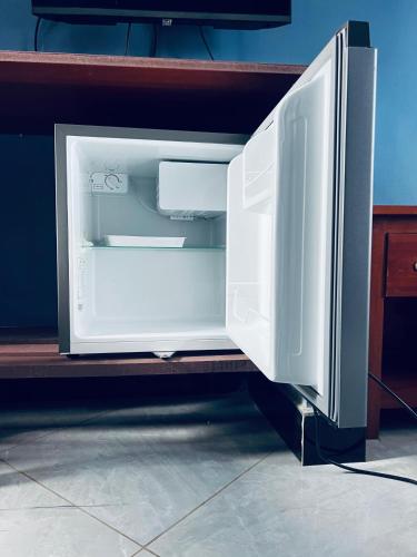 an open refrigerator with its door open on a shelf at Elly Villa Hotel in Moshi