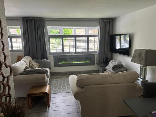 a living room with two couches and a fireplace at The Quarry Woolton Village in Childwall