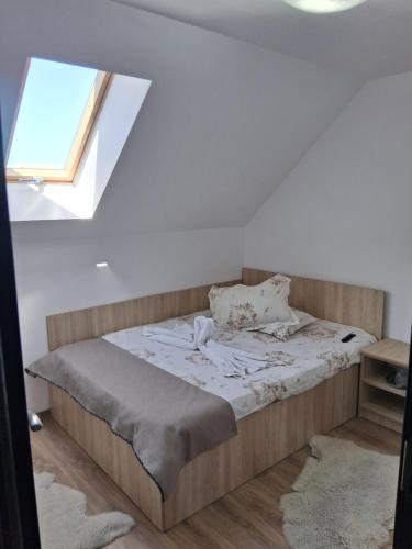 ein Schlafzimmer mit einem Bett in einem Zimmer mit Fenster in der Unterkunft Casa Marylo in Bran