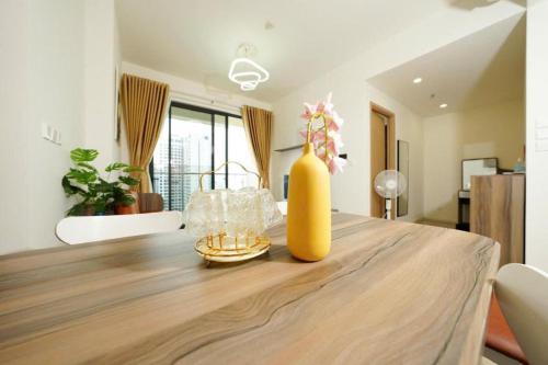 a dining room table with a yellow vase on it at Origami Vinhomes Grand Park Q9 in Gò Công