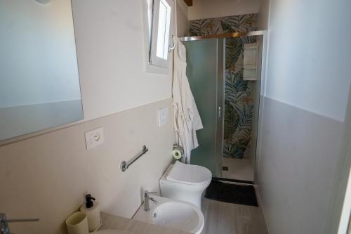 a bathroom with a toilet and a sink at White & Grey in Supersano