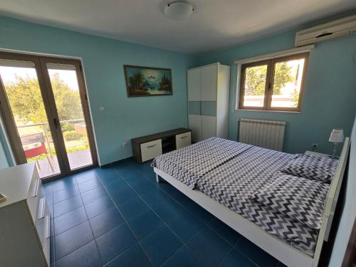 a bedroom with a bed and blue walls and windows at Villa Relax Apartments in Budva