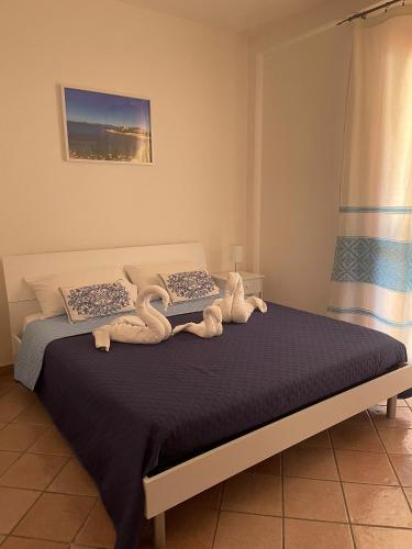 a bed with two stuffed animals on top of it at La Casa di Lore & Leo in Alghero