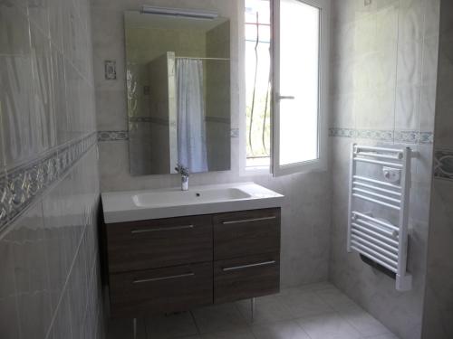 ビアリッツにあるMaison du Lavoir d'Ilbarritzのバスルーム(洗面台、鏡、窓付)
