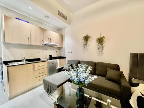 a living room with a couch and a kitchen at 3 mins walk to ADCB metro in Dubai