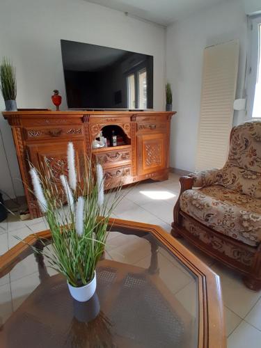 a living room with a tv and a couch and a table at Chambres de charme en Normandie in Hauterive
