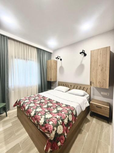 Bakurianis AndezitiCottage ANKANAKEBA的一间卧室配有一张带花卉图案的毯子的大床