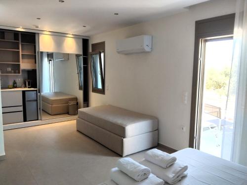 a large white room with a bed and a stool at Luminous Luxury Apartments in Limenas